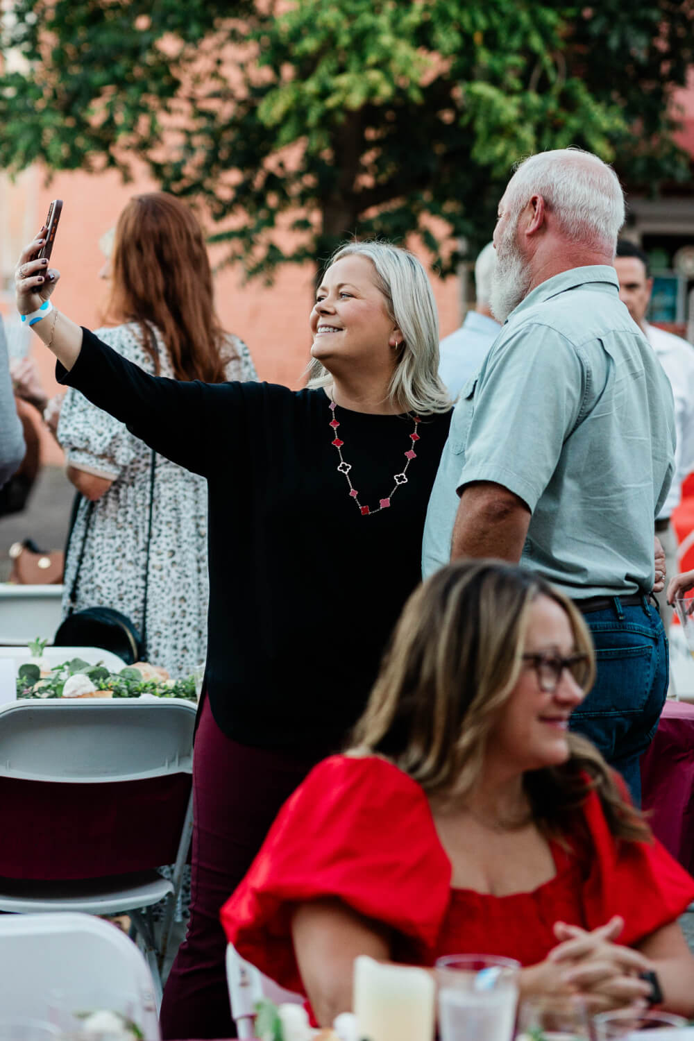 A woman taking a selfie with a man during Plates on Pruett.