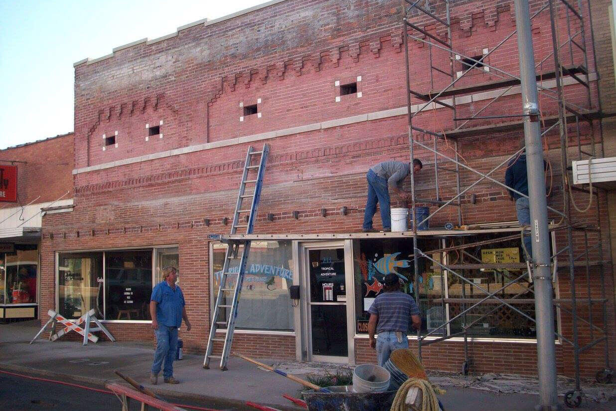 Group of people repairing a storefront in Downtown Paragould.