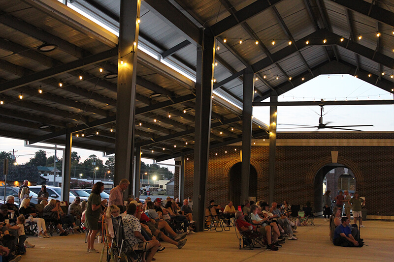Outside at the Community Pavilion with people enjoying a show.