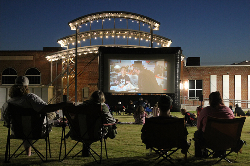 The Station's amphitheater lawn with people watching a movie