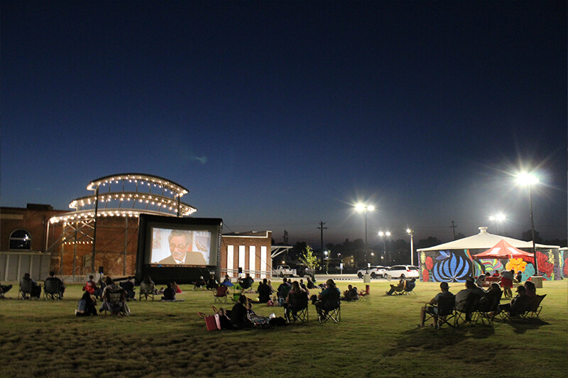 The Station's amphitheater lawn with people watching a movie